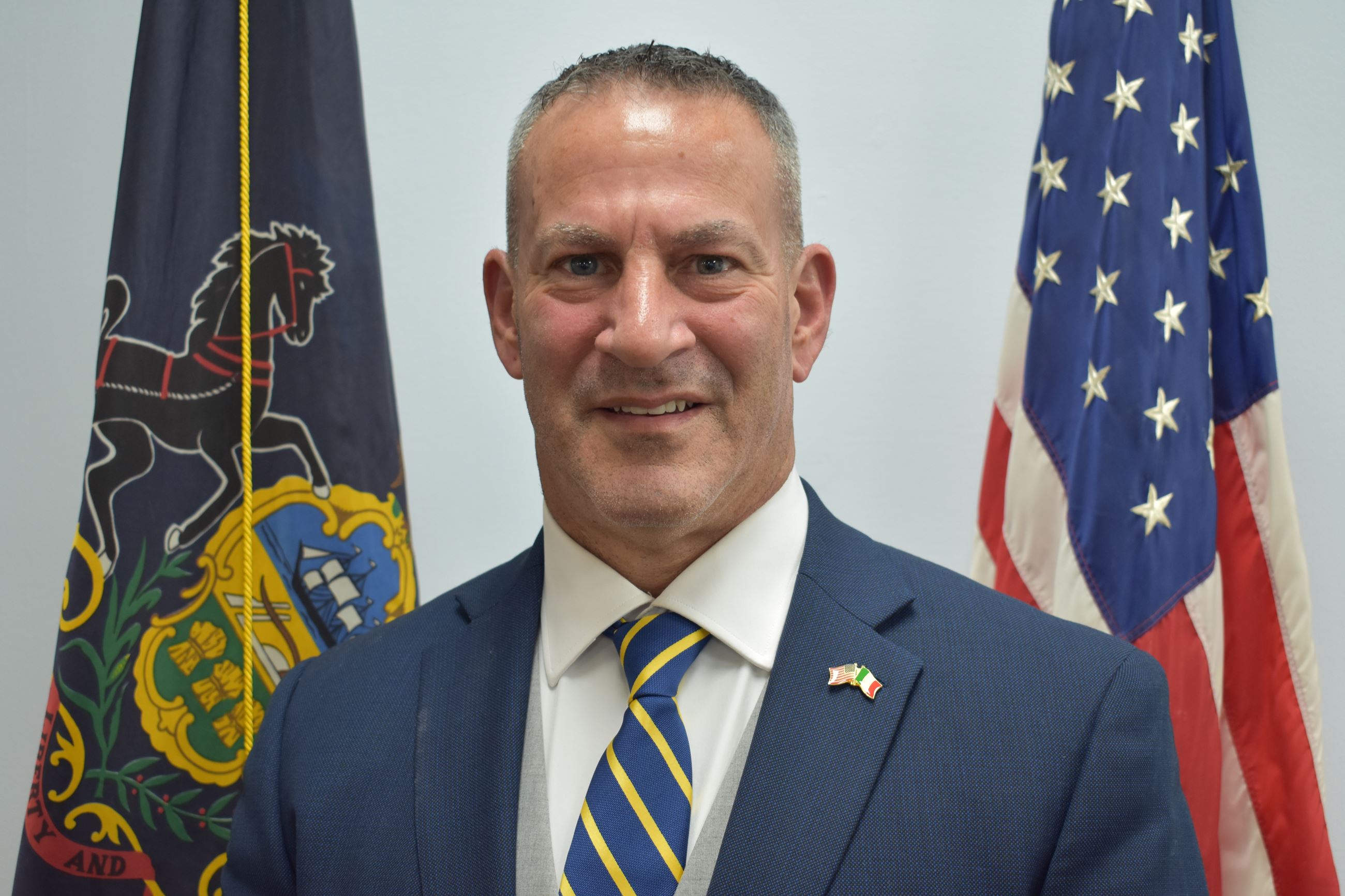 Commissioner Ron Zona with Flags in the Background
